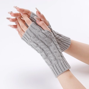 Close-up of grey cable-knit fingerless gloves featuring a classic diamond weave pattern