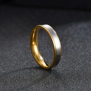 Polished two-tone stainless steel ring for men and women on black textured background