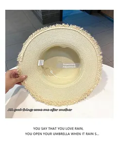 Detail of adjustable drawstring inside the beige paper straw hat with frayed edges