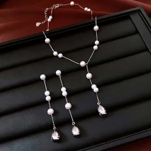 French vintage pearl drop necklace and earrings jewelry set on a dark textured display
