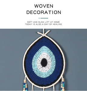Detail of bohemian evil eye dreamcatcher with cotton threads and colorful wooden beads
