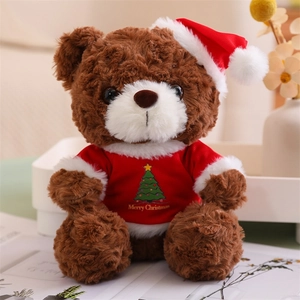 Close-up of brown teddy bear wearing a Merry Christmas sweater and festive red hat