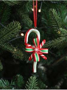 Close-up of a festive red and white candy cane ornament hanging on a Christmas tree