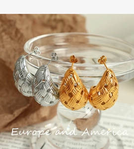Detail of hollow braided water drop earrings in gold and silver plating on glass