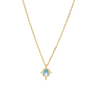 Elegant gold North Star necklace with a blue topaz gemstone center on a white background