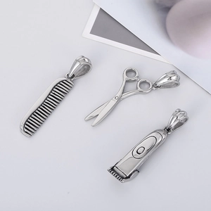 Detailed close-up of silver steel barber set pendants with comb, scissors and clipper charms