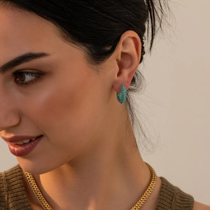 Detail of turquoise beaded hoop earrings in gold finish worn by model showing scale