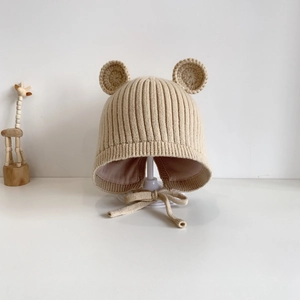 Detail der Baby-Strickmütze mit Bärenohren und Kinnriemen in beigem Garn