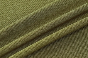 Close-up of green knitted fabric texture and elegant pleated details on the dress