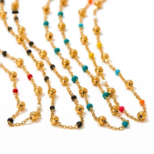 Detailed close-up of bohemian colorful beads on golden stainless steel necklace chain