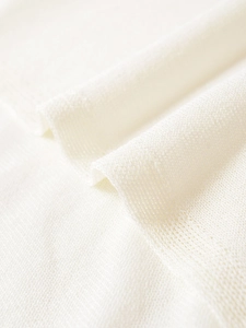 Close-up of the breathable white knit fabric showing fine mesh structure and soft texture