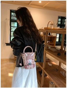 Detailed view of pink mini bucket bag with bunny charm and monogram leather pattern