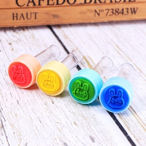 Detailed view of four colorful plastic cartoon rabbit stamps in red, yellow, green and blue