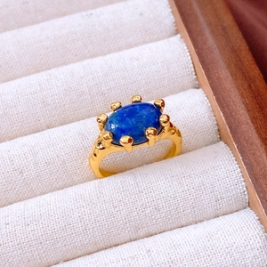 Detail of 18K gold plated ring with a large oval blue lapis stone in a vintage setting