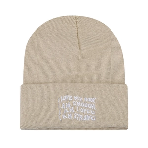 Beige knitted beanie featuring white positive affirmation quotes and a cuffed design