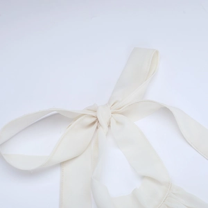 Detaillierte Nahaufnahme einer cremefarbenen Chiffon-Schleife mit feinen Nähten