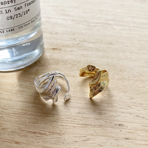 Close-up of S925 silver open ring with irregular crumpled texture on wooden surface