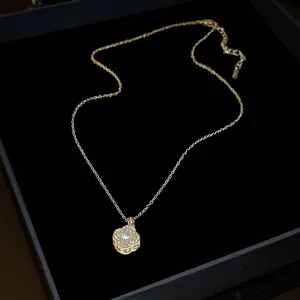 Elegant gold four-leaf clover pendant necklace with sparkling cubic zirconia stones in box