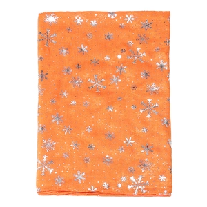 Détail d'une écharpe orange de Noël avec motifs de flocons d'argent et pois sur le tissu