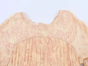 Dettaglio di abito in chiffon floreale con perline argento e tessuto a pieghe