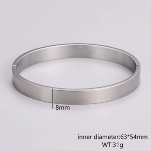 Close-up of 8mm stainless steel bangle with brushed metal texture and snap closure