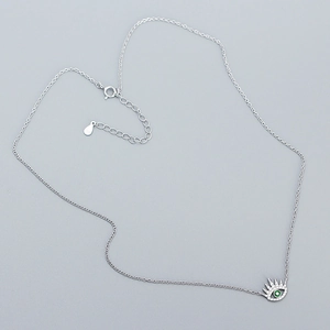 Detail view of 925 sterling silver evil eye necklace with green stone and pavé zircons