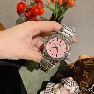 Detailed macro view of a silver steel strap watch featuring a soft pink sunray dial with calendar