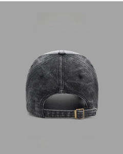 Detail of grey washed cotton baseball cap with adjustable gold metal buckle on back