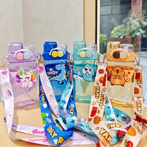 Row of colorful cartoon kids water bottles with straws and straps on a wooden table
