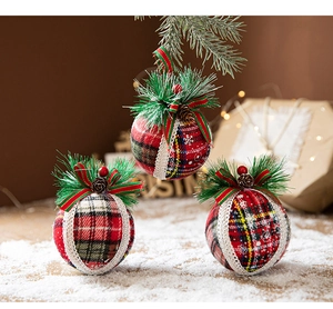 Close-up of plaid Christmas ornaments with pine needles, cones and red berries detail