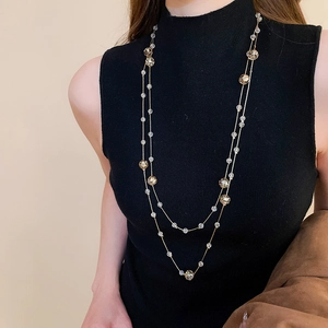 Double-layered gold necklace with clear and champagne crystals on black knit background