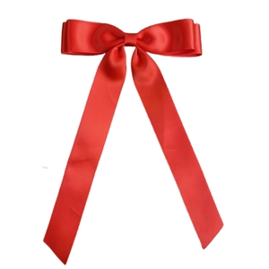 Close-up of a double-layered red satin ribbon bow hair clip with elegant long streamers