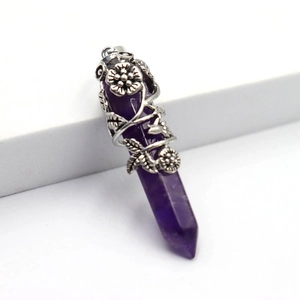 Détail macro du pendentif hexagonal en améthyste avec décoration de vigne florale argentée