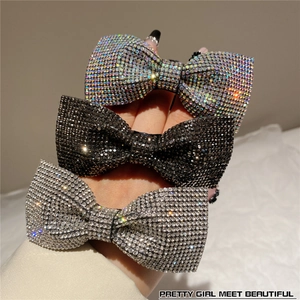 Close-up of sparkling rhinestone bow hair clips in silver, black, and iridescent colors
