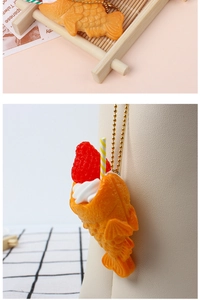 Macro detail of Taiyaki shaped resin pendant with cream and strawberry filling charms