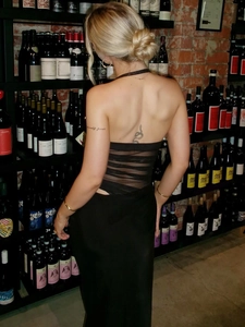Robe noire sexy dos nu avec empiècement en tulle et dos nu dans une cave à vin élégante
