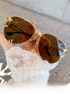 Close-up of golden leopard head emblem on stylish double-bridge aviator sunglasses