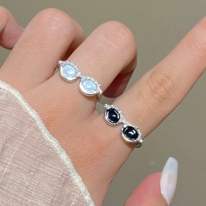 Detailed view of creative sunglasses rings in silver with black and white opal-like stones