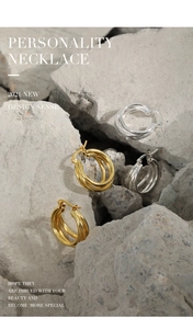 Detail view of multilayer geometric S925 sterling silver hoop earrings in gold and silver