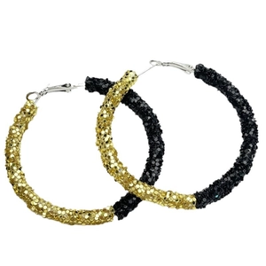 Close-up of oversized hoop earrings with glittering sequins in gold and black finishes