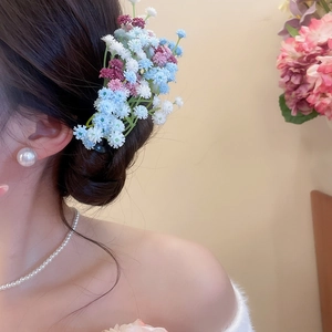 Detail view of colorful acrylic flower hair clips styled with elegant jewelry for women