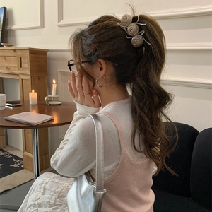 Barrettes à cheveux élégantes avec roses en tissu crème portées par un mannequin