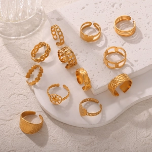 Set of 11 gold layered rings with heart and geometric textures on minimalist display