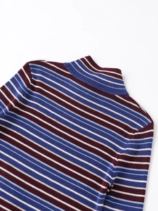Macro shot of mock neck collar stitching on burgundy and blue striped knit sweater