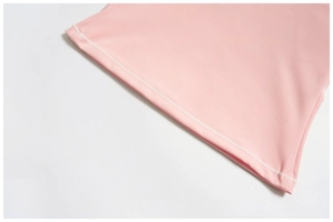 Gros plan détaillé de l'ourlet à double couture sur un débardeur de yoga rose respirant