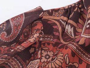 Close-up of red paisley print and lightweight chiffon fabric on a bohemian dress