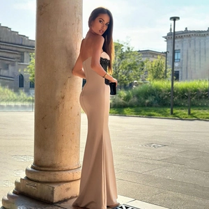 Detail view of bodycon mermaid dress with beige fabric and black lace stitching accents