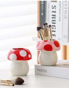 Detailed view of two cute mushroom ceramic pen holders for makeup brushes and stationery