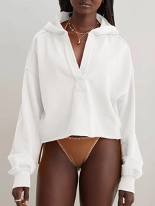 Detail der weißen Strickkapuzenjacke und der braun gewebten Bikini-Hose mit Textur
