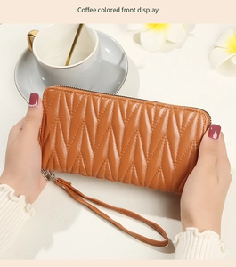 Detailed front view of coffee brown quilted wristlet wallet with V-pattern texture